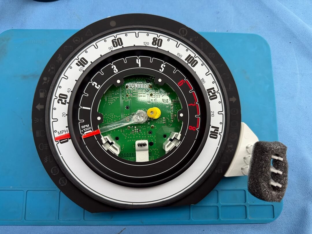 Fiat 500 instrument cluster opened on the bench with the old LCD removed and the circuit board visible
